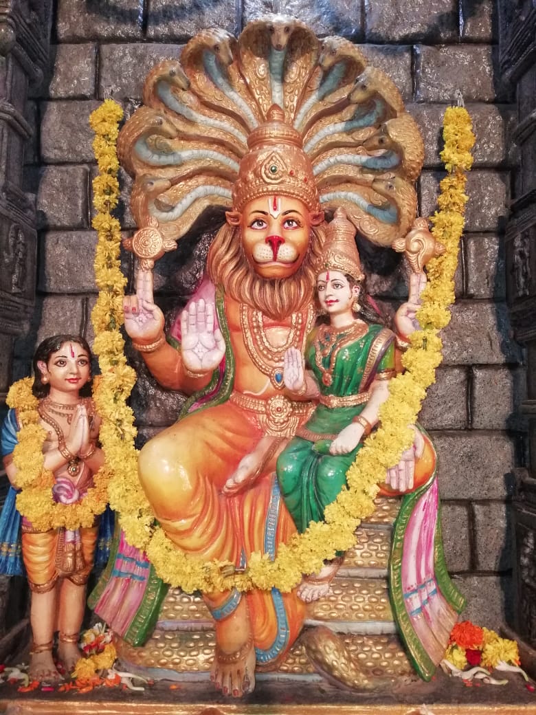 Sri Lakshmi Narasimha Swamy with Lakshmi Devi on His lap and Prahlada at His side, adorned with marigold garlands